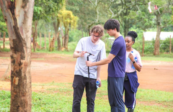 Maxwell and teammates taking measurements outdoors in Kenya